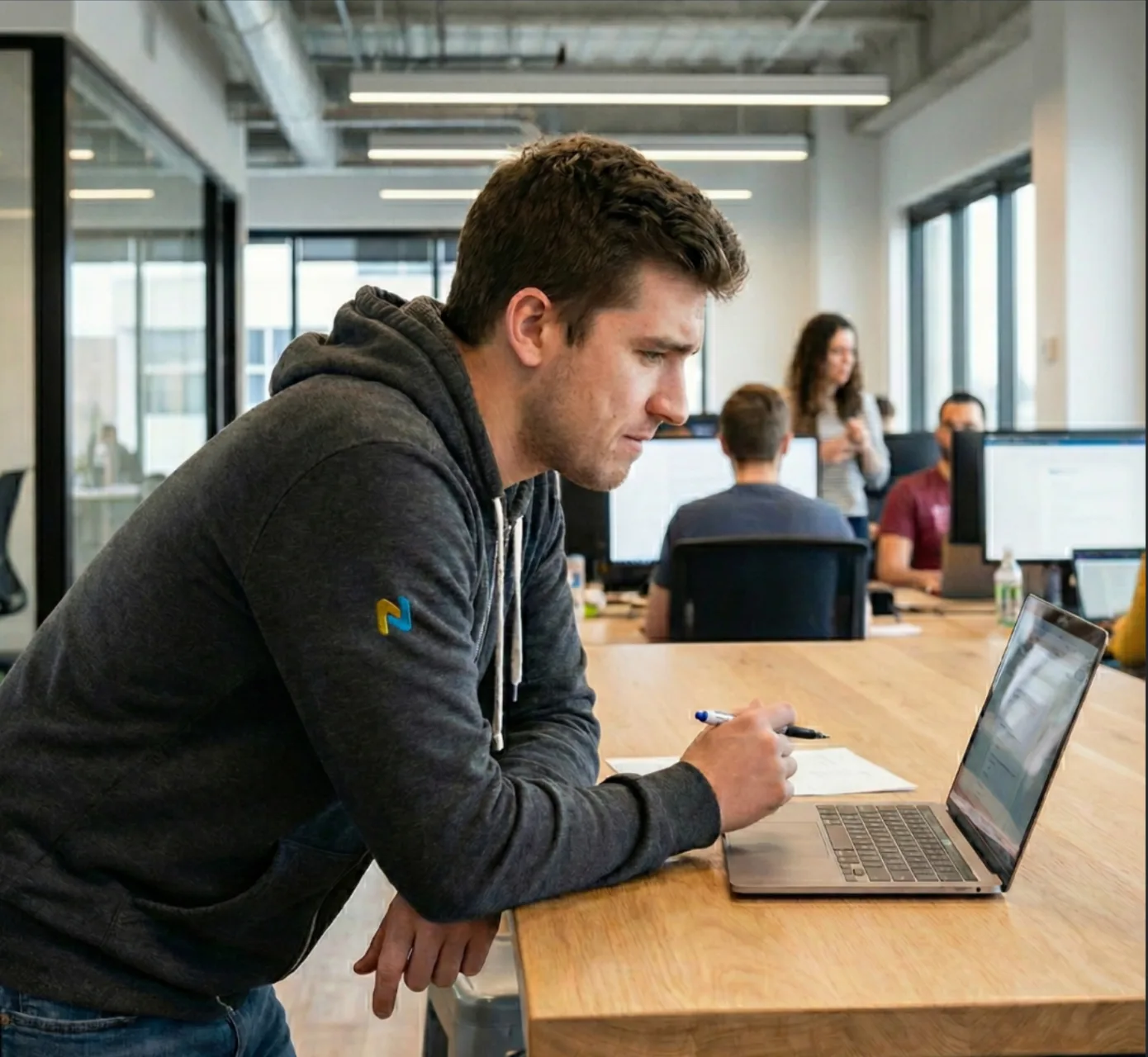 A Numinor team member reviewing a client's QuickBooks file at a laptop, with the wider Waterloo team working in the background.